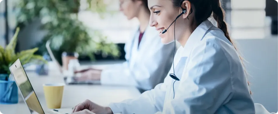 Mujer joven  sociosanitaria en contact center hablando con una persona mayor.